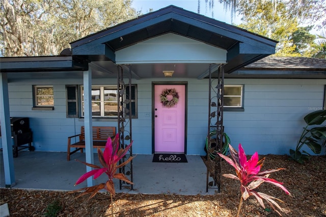 view of exterior entry featuring covered porch