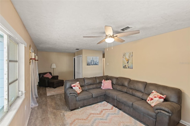 living room with ceiling fan, hardwood / wood-style flooring, and a textured ceiling