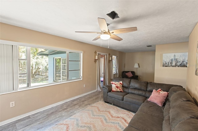 living room with ceiling fan, wood-type flooring, and a textured ceiling