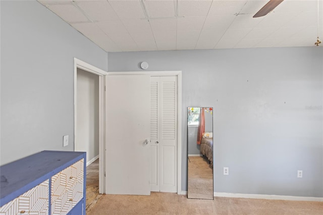 carpeted bedroom with ceiling fan and a closet