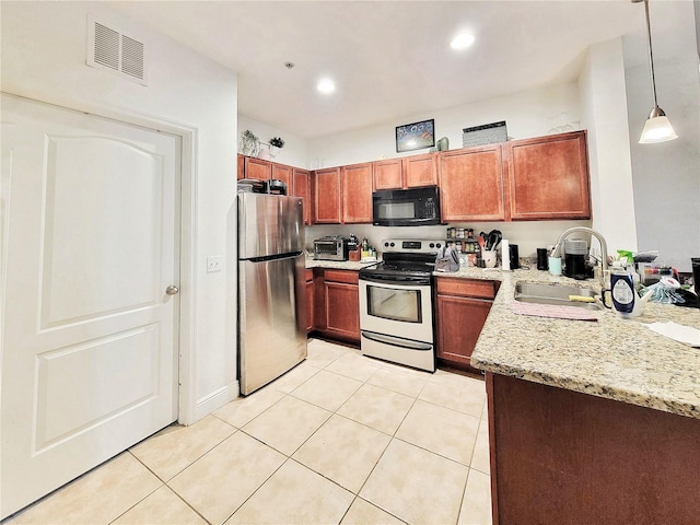 kitchen with sink, light tile patterned floors, stainless steel appliances, light stone counters, and decorative light fixtures