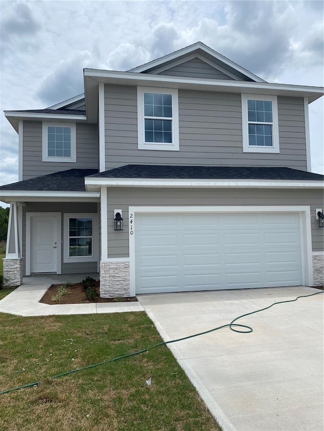 view of front of home featuring a garage and a front lawn