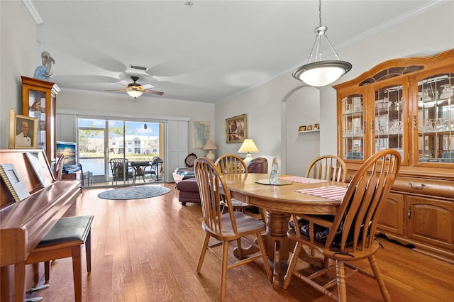 dining room featuring ceiling fan, ornamental molding, and light hardwood / wood-style floors