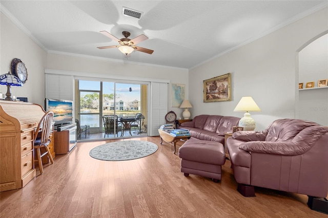 living room with light hardwood / wood-style flooring, ornamental molding, and ceiling fan