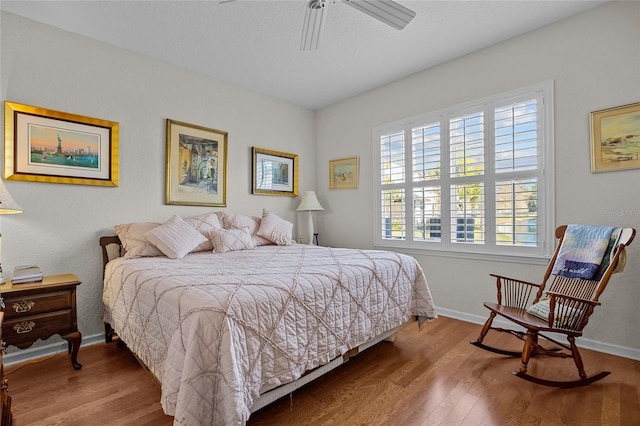 bedroom featuring hardwood / wood-style flooring, ceiling fan, and a textured ceiling