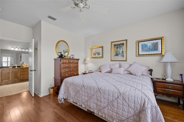 bedroom featuring hardwood / wood-style flooring, ceiling fan, and ensuite bathroom