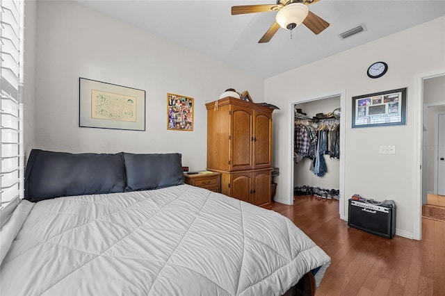 bedroom featuring dark hardwood / wood-style flooring, a walk in closet, a closet, and ceiling fan