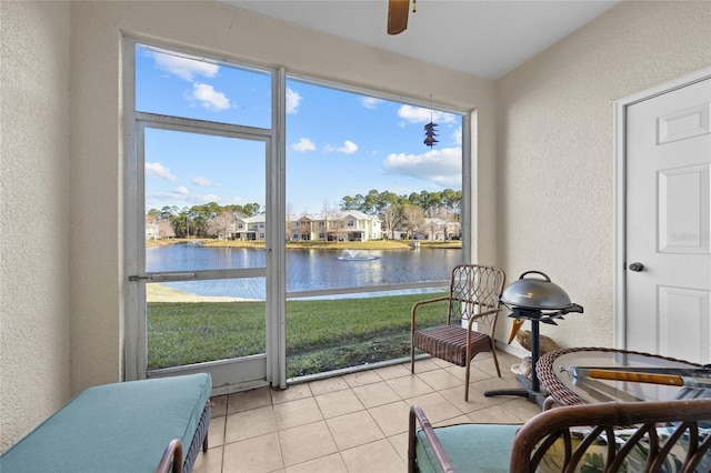 sunroom with a water view and ceiling fan