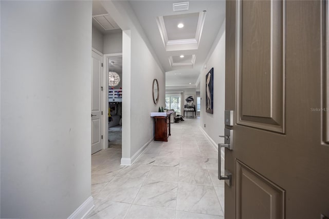 hall featuring a raised ceiling and ornamental molding