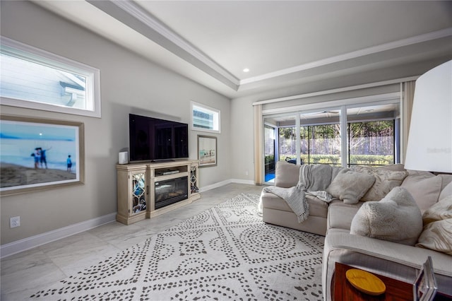 living room with a tray ceiling, a high end fireplace, and a healthy amount of sunlight