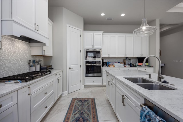 kitchen featuring white cabinetry, sink, hanging light fixtures, stainless steel appliances, and light stone countertops