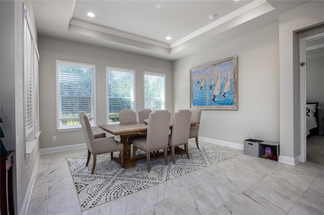 dining area featuring ornamental molding and a raised ceiling