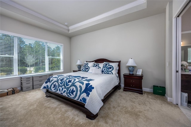 bedroom with crown molding, a tray ceiling, and light colored carpet