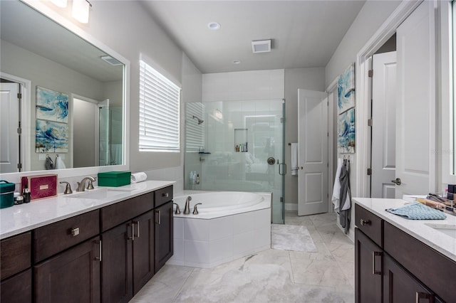 bathroom with vanity and shower with separate bathtub