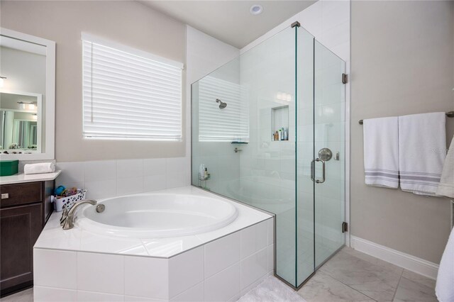 bathroom with vanity and shower with separate bathtub