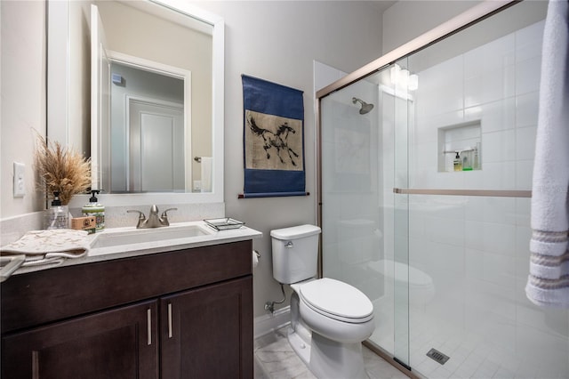 bathroom with vanity, a shower with shower door, and toilet