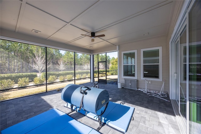 unfurnished sunroom with ceiling fan