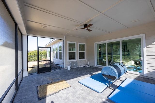 unfurnished sunroom with ceiling fan