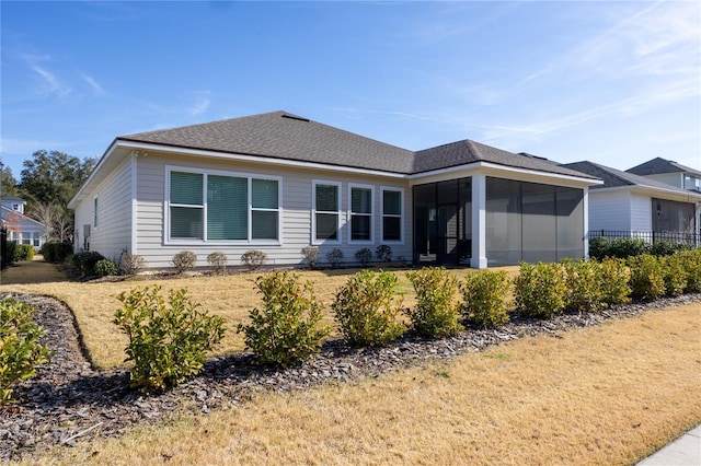 view of property exterior with a sunroom and a lawn