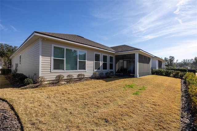 back of house with a yard and a sunroom