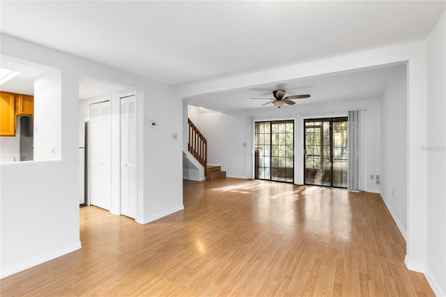 empty room with ceiling fan and light hardwood / wood-style floors