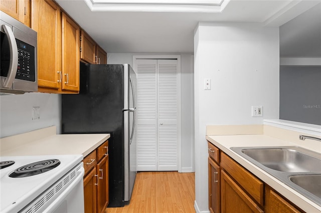 kitchen with white electric range, sink, and light wood-type flooring