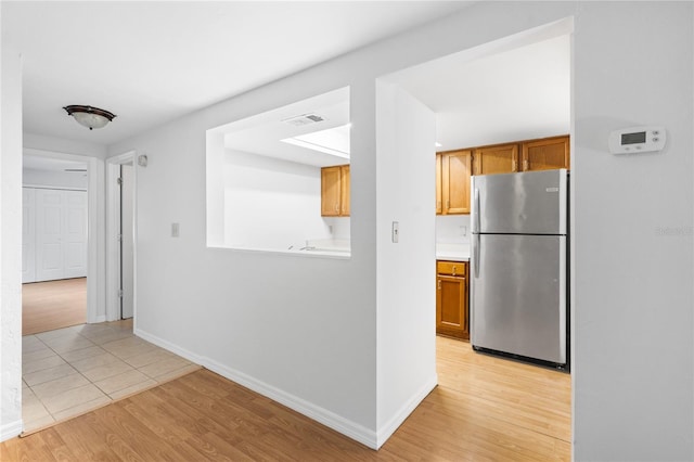 kitchen featuring light wood-type flooring and stainless steel refrigerator