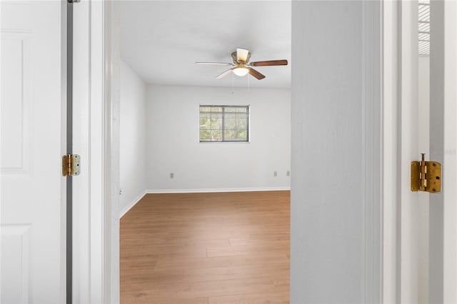 empty room with ceiling fan and light hardwood / wood-style floors