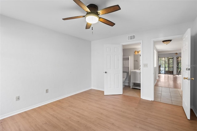 unfurnished bedroom featuring ensuite bath and light wood-type flooring