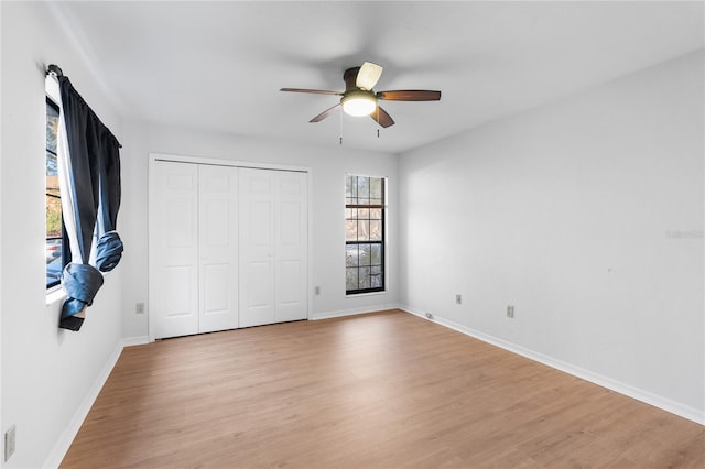 unfurnished bedroom featuring light hardwood / wood-style floors, a closet, and ceiling fan