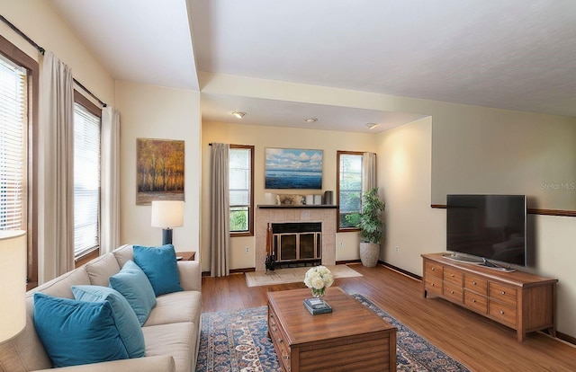 living room with a fireplace and light wood-type flooring