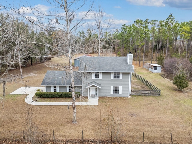 view of front of house with an outbuilding and a front lawn