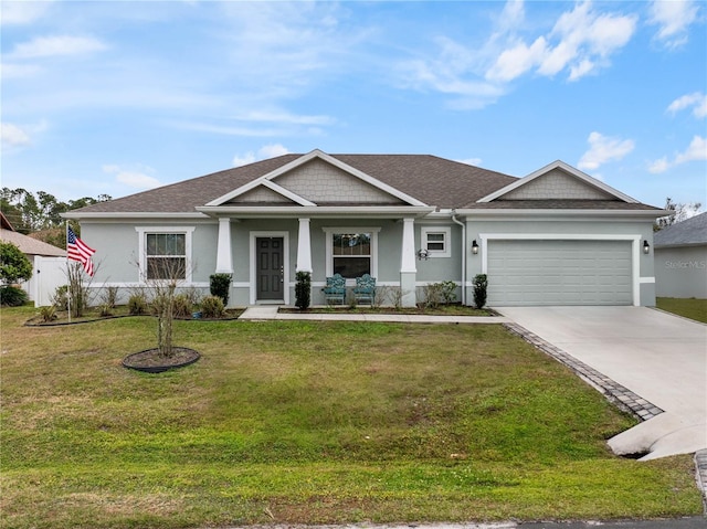 view of front of property with a garage, a front lawn, and covered porch