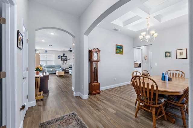 dining room featuring beamed ceiling, wood-type flooring, coffered ceiling, and ceiling fan with notable chandelier