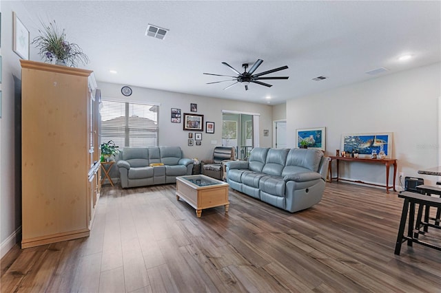 living room featuring dark hardwood / wood-style flooring and ceiling fan