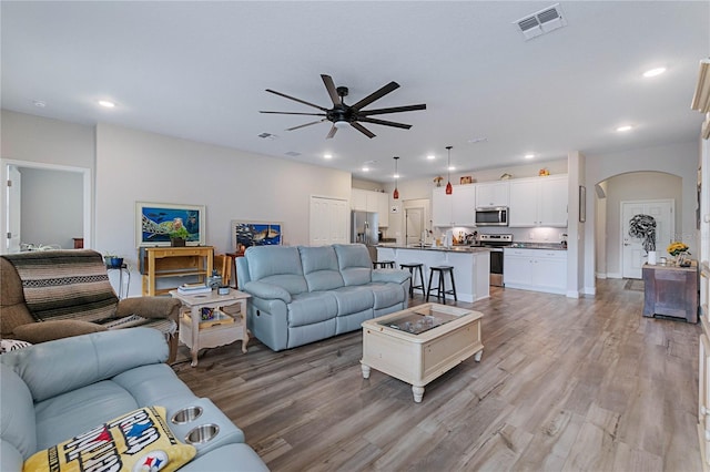 living room with ceiling fan and light hardwood / wood-style floors