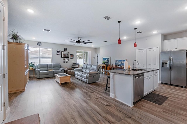 kitchen featuring white cabinetry, stainless steel appliances, and a kitchen island with sink