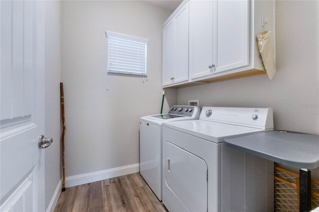 washroom featuring cabinets, hardwood / wood-style floors, and independent washer and dryer