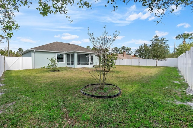 rear view of house with a yard and a sunroom