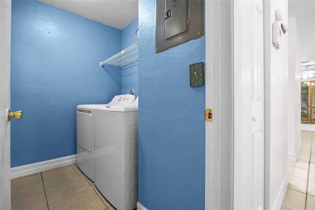 clothes washing area with washer and dryer and light tile patterned floors