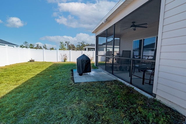 view of yard with ceiling fan, a sunroom, and a patio