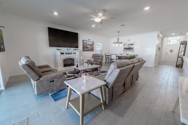 living room featuring crown molding and ceiling fan with notable chandelier