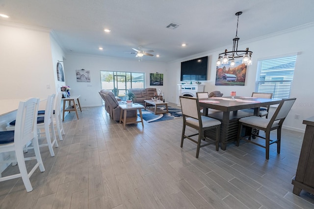 dining space featuring crown molding, hardwood / wood-style flooring, and ceiling fan with notable chandelier