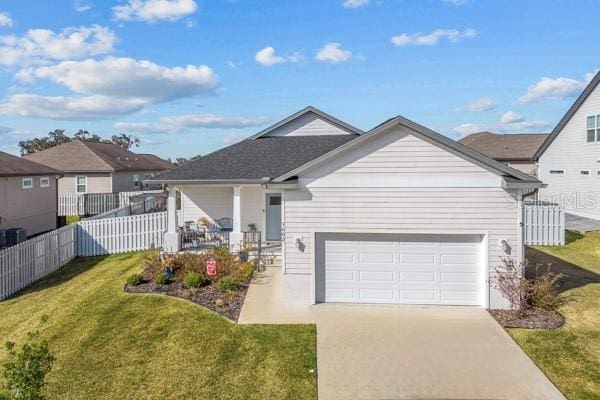 view of front of home with a garage, a front yard, and covered porch