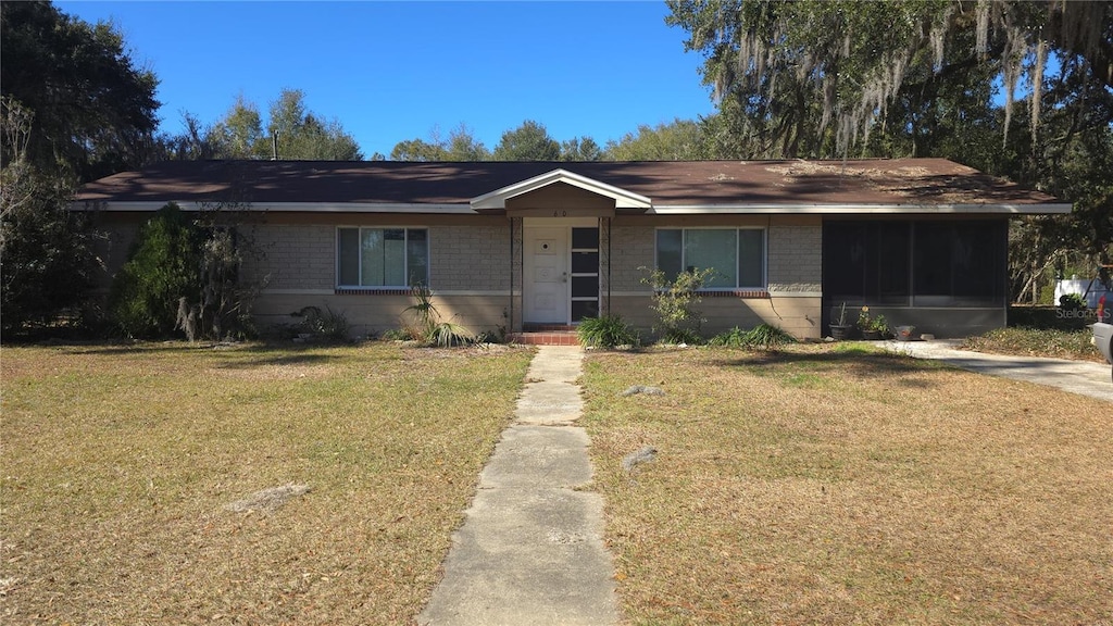 ranch-style home with a sunroom and a front yard