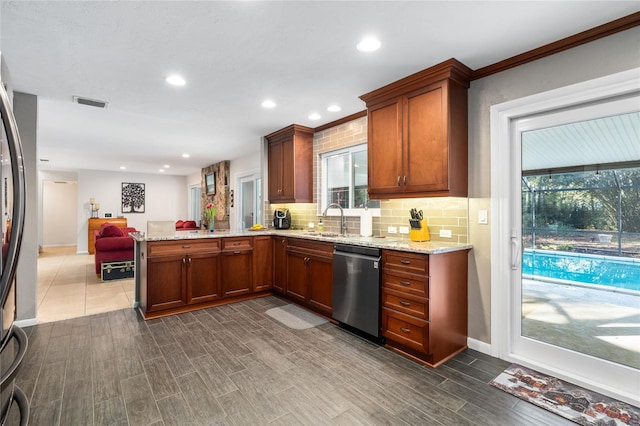 kitchen featuring a peninsula, a sink, open floor plan, decorative backsplash, and dishwasher