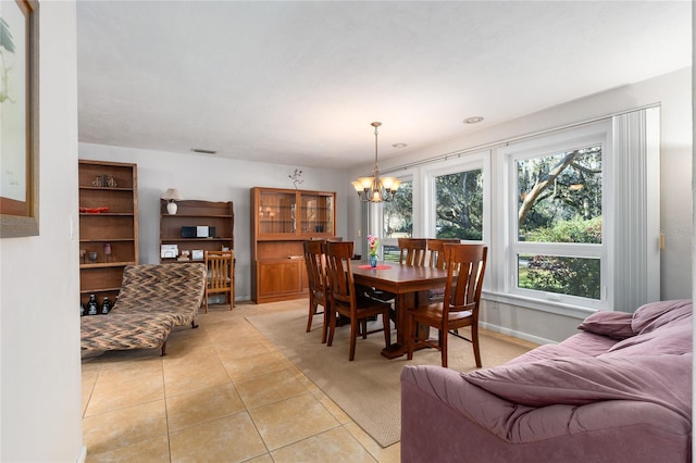 dining area featuring light tile patterned floors, a chandelier, visible vents, and baseboards