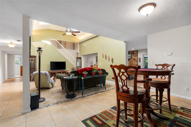 dining area featuring light tile patterned flooring, visible vents, a ceiling fan, stairs, and baseboards