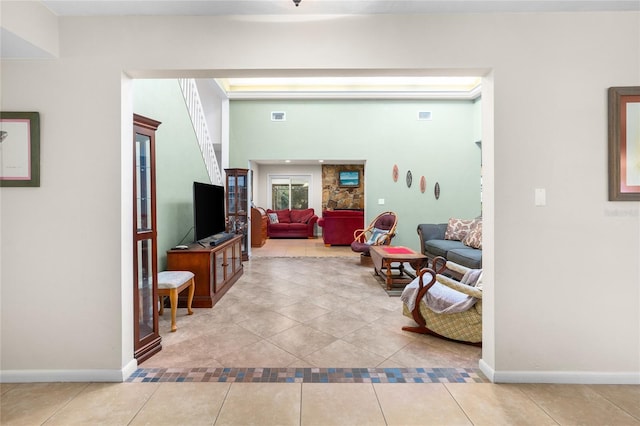 living area featuring light tile patterned flooring, visible vents, and baseboards