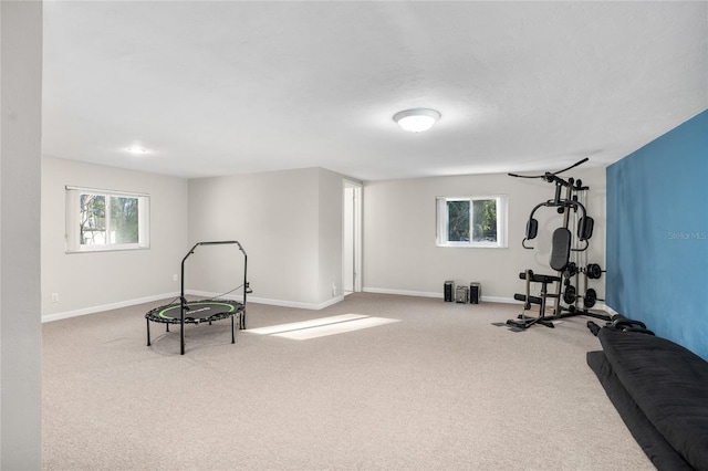 exercise room with carpet floors and baseboards